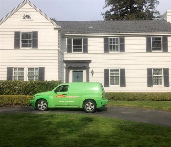 SERVPRO vehicle parked in front of a white home. 